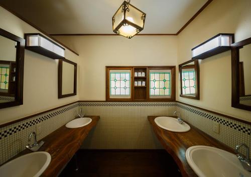 a bathroom with three sinks and two mirrors at Kannomori in Yufuin