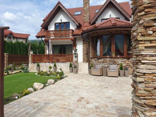 a house with a stone pathway leading to a patio at Poiana Golf Chalet in Buşteni