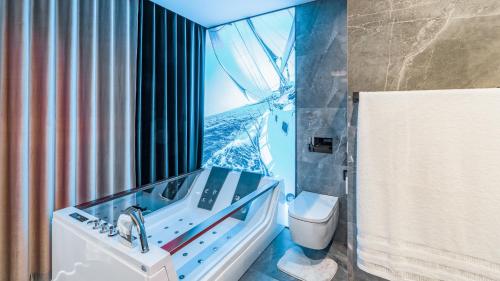 łazienka z wanną, umywalką i toaletą w obiekcie Apartamenty Stranda Residence nad jeziorem Mazury Holiday w mieście Giżycko