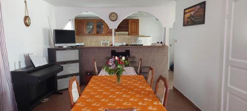 a dining room with a table with chairs and a kitchen at Casa Dunarea in Chilia Veche