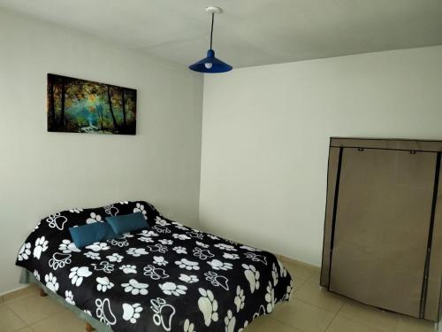 1 dormitorio con 1 cama en blanco y negro y armario en D&D alojamiento en Guaymallén