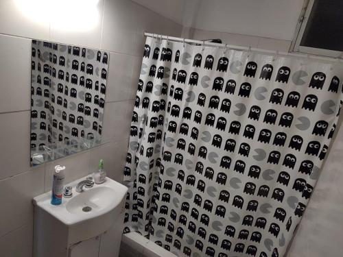 baño con cortina de ducha con caras blancas y negras en D&D alojamiento en Guaymallén