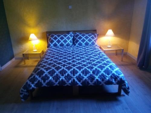 a blue bed in a bedroom with two lamps at nature en petite montagne in Arinthod