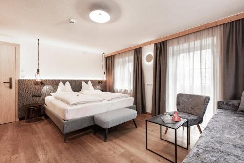 a hotel room with a bed and a couch at Urbanhof in Sölden