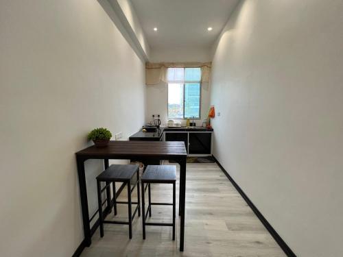 a kitchen with a table and stools in a room at One Point Inn King Centre in Kuching