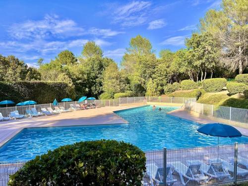 einen Pool mit Stühlen und Sonnenschirmen in einem Resort in der Unterkunft Jolie maison familiale in Valbonne