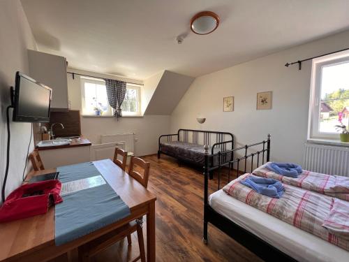 ein Wohnzimmer mit 2 Betten, einem Tisch und einem Bett in der Unterkunft Penzion Farma Žleby in České Žleby