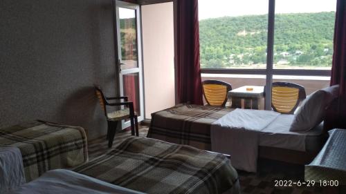a room with two beds and a large window at Motel in Qusar