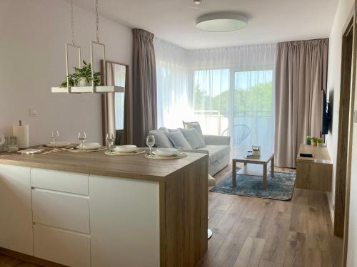 cocina y sala de estar con mesa y sofá en Apartament nr 29 - Apartamenty Wakacyjna 5 en Mielno