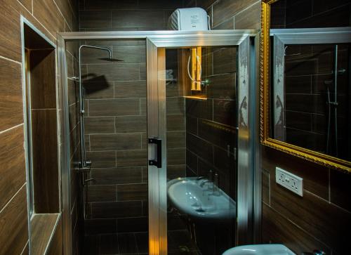 ein Bad mit einem Waschbecken und einem Spiegel in der Unterkunft Nap Apartment Hotel in Dansoman