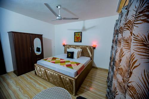 Schlafzimmer mit einem Bett und einem Deckenventilator in der Unterkunft Nap Apartment Hotel in Dansoman
