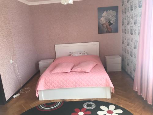 a small bedroom with a pink bed with pink sheets at Sweet Home in Kutaisi