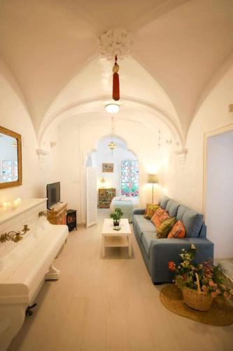 a living room with a blue couch and a table at La Boveda de Hércules in Medina Sidonia