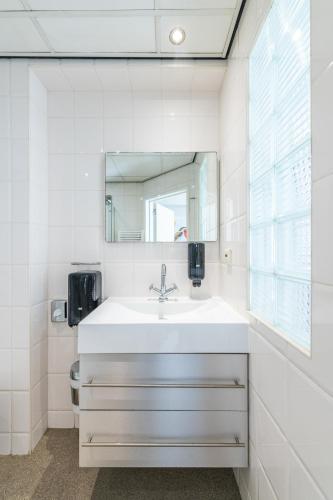 a white bathroom with a sink and a mirror at Japie rooms - in the heart of Antwerp in Antwerp