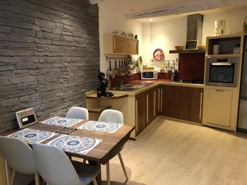 une cuisine et une salle à manger avec une table et des chaises dans l'établissement La Maison du Pescadou Gruissan Village-Autentique-Plage, à Gruissan