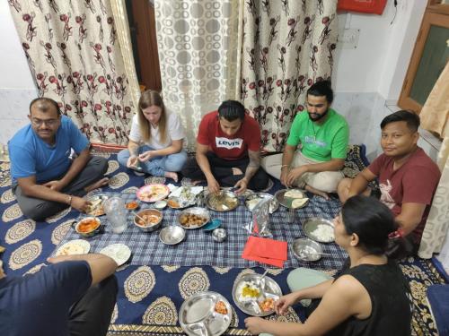 a group of people sitting around a table eating food at Mir manzil in Srinagar