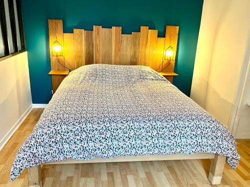a bed with a wooden headboard in a bedroom at Agréable gîte au coeur du centre ville 4 personnes in Chagny