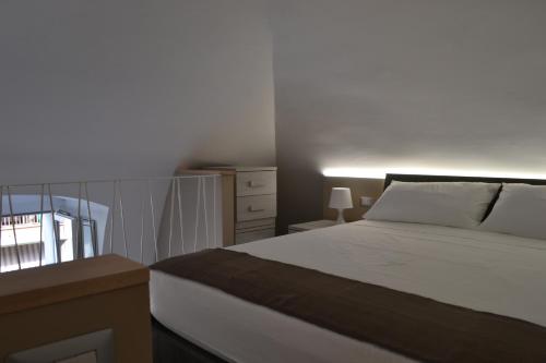 1 dormitorio con 1 cama, vestidor y ventana en MargaretHome, en Gravina in Puglia