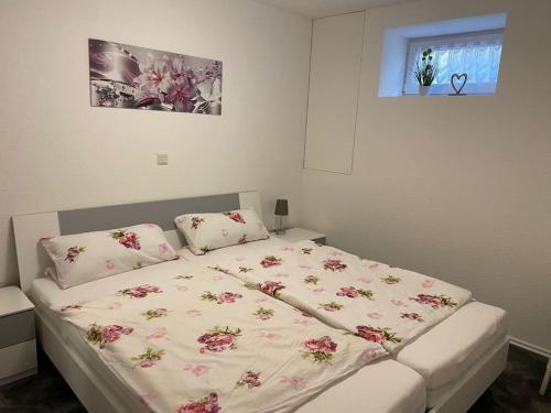 a bedroom with a bed with pink flowers on it at Büschem Wohlfühlparadies in Lindlar