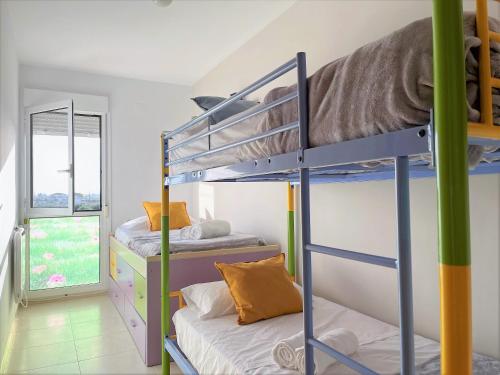 2 łóżka piętrowe w pokoju z oknem w obiekcie Lo Petit Delta w mieście El Lligallo del Gànguil