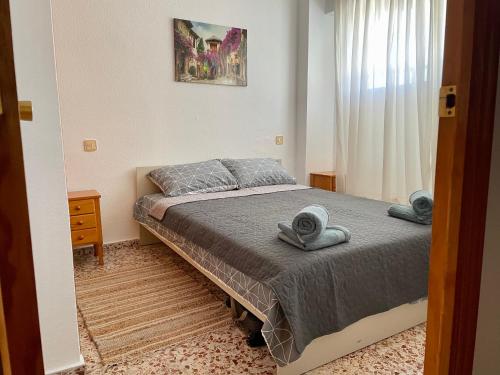 1 dormitorio con 1 cama con toallas en Portus apartment with pool, en Santa Pola