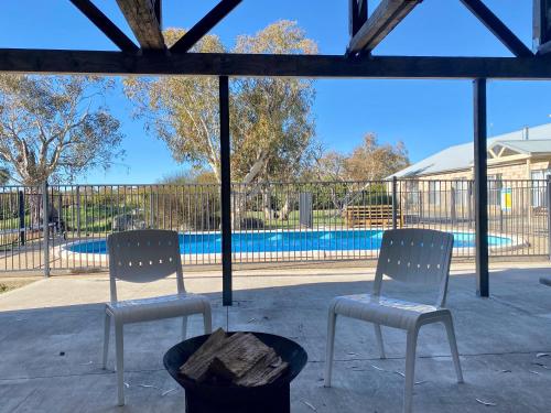 two chairs sitting in front of a swimming pool at Winterwood Lodge - 6mins Jindabyne Pets Allow Farm Stay-Swimming Pool Summer Only in Moonbah