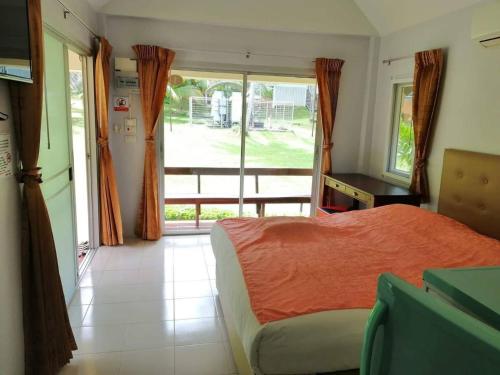 a bedroom with a bed and a large window at เกาะช้างรักดี รีสอร์ท in Ko Chang