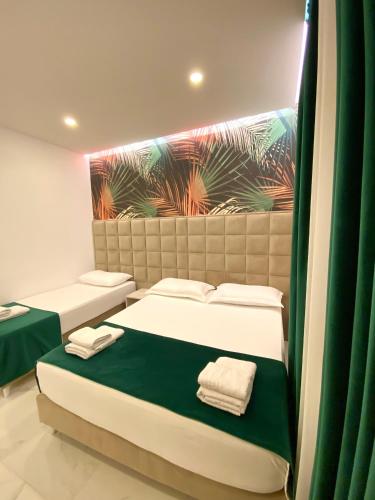 two beds in a room with green and white at Apartments Oda Hotel in Velipojë