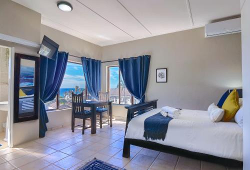 a bedroom with a bed and a table and chairs at Ocean View Villas in Ballito