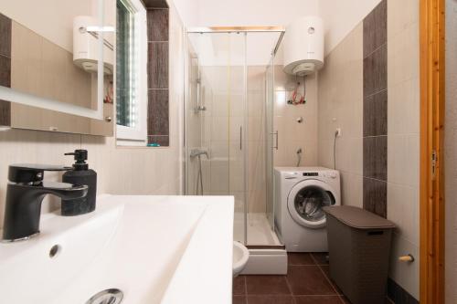 La salle de bains est pourvue d'un lavabo et d'un lave-linge. dans l'établissement House Boris, à Loborika
