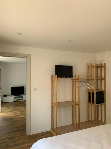 une chambre avec un lit et une télévision et une chambre avec une chambre dans l'établissement Chez mémère, Vosges, à Saint-Étienne-lès-Remiremont