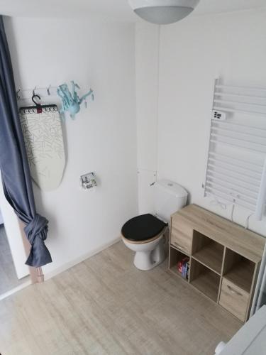 La salle de bains blanche est pourvue de toilettes et d'une table. dans l'établissement Logement entier indépendant dans une maison calme avec jardin barbecue face aux vignes pouvant accueillir cette personne très bien si tu es à 5 minutes de Saint-Émilion 5 minutes du centre-ville de Libourne et 5 minutes de l'hôpital, à Libourne