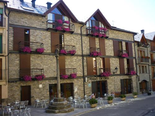 a building with tables and chairs in front of it at Pensio La Creu in Esterri d'Àneu