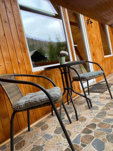 a table and chairs in a room with a window at Cabanutze Satic in Rucăr