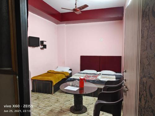 um pequeno quarto com uma mesa e uma cama em Sudha sadan em Lucknow