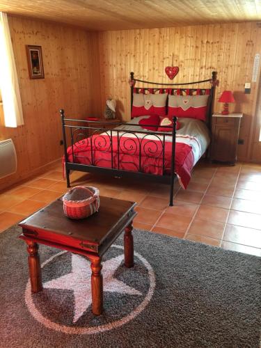 Le chalet de Doucy Bardet في Habère-Poche: غرفة نوم بسرير وطاولة في غرفة