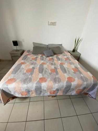 uma cama com um edredão num quarto em Casa a 5 minutos del mar em Mazatlán