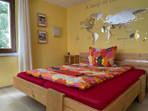 1 dormitorio con 1 cama con un mapa del mundo en la pared en Direkt am Main en Karlstadt