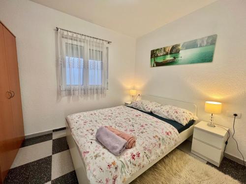 a small bedroom with a bed and a window at Apartmani Ana in Dramalj