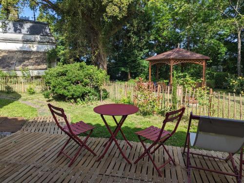 uma mesa e duas cadeiras e um gazebo em L'annexe de la verrerie em Cognac