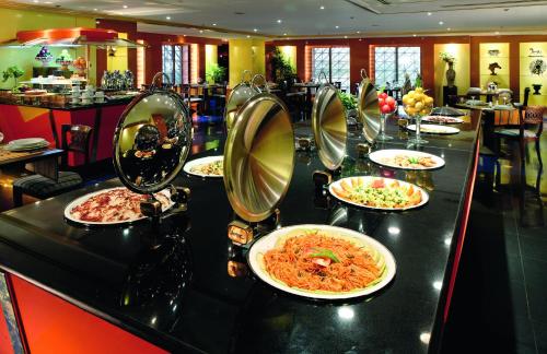 a buffet line with plates of food in a restaurant at New Madinah Hotel in Al Madinah