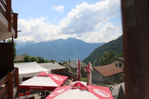 a group of umbrellas on a balcony with mountains at Le Vieux Valais in Ovronnaz