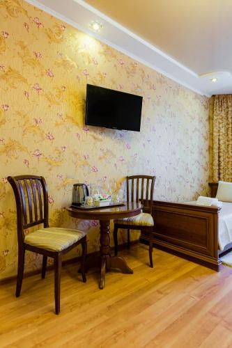 a room with a table and two chairs and a bed at Poznyakoff Aparthotel in Kyiv