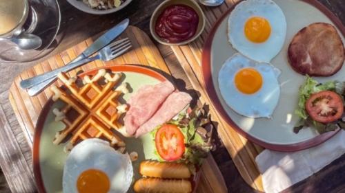 a table with two plates of eggs and ham and french fries at Koh Tao Cabana in Koh Tao