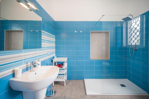 a blue tiled bathroom with a sink and a tub at B&B Casina de Goyzueta in Torre del Greco