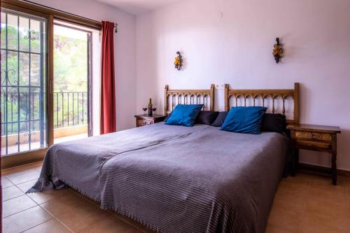 a bedroom with a large bed with blue pillows at Casa Soluna in Jávea