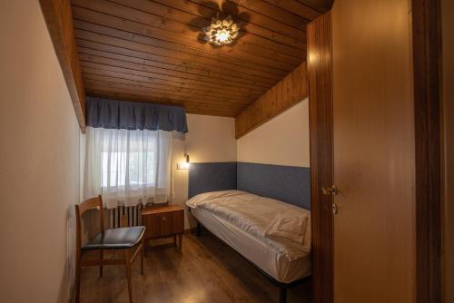博爾查迪卡多爾的住宿－Casa Lino，一间小卧室,配有一张床和一把椅子