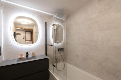une salle de bain avec une douche, un lavabo et un miroir dans l'établissement Bel appartement entier en style Chalet à Chamonix, à Chamonix-Mont-Blanc