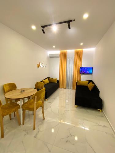 a living room with a table and chairs and a couch at Apartments Oda Hotel in Velipojë