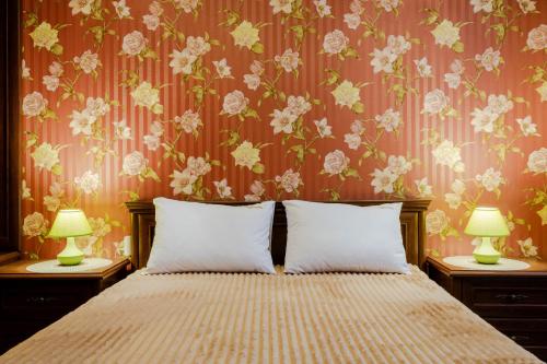 a bedroom with a bed with a floral wallpaper at Poznyakoff Aparthotel in Kyiv